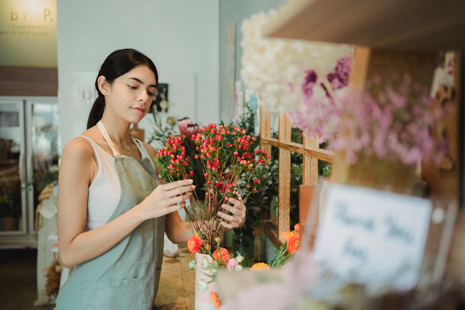 A vibrant flower display at Wheeler of Chiswick inside an underground station, featuring a variety of fresh flowers arranged in bouquets and buckets with blooms in shades of pink, white, red, yellow, 